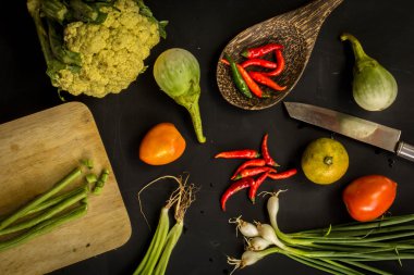 Young spring vegetables on black chalkboard from above. Backgrou