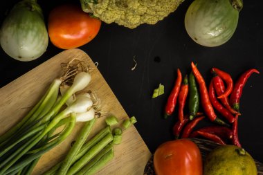 Young spring vegetables on black chalkboard from above. Backgrou