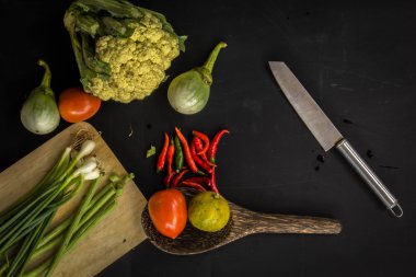 Young spring vegetables on black chalkboard from above. Backgrou