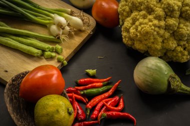 Young spring vegetables on black chalkboard from above. Backgrou
