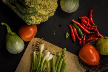 Young spring vegetables on black chalkboard from above. Backgrou