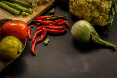 Young spring vegetables on black chalkboard from above. Backgrou