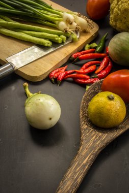 Young spring vegetables on black chalkboard from above. Backgrou
