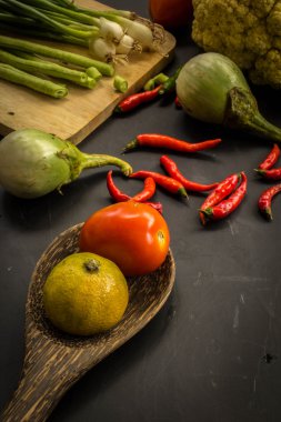 Young spring vegetables on black chalkboard from above. Backgrou