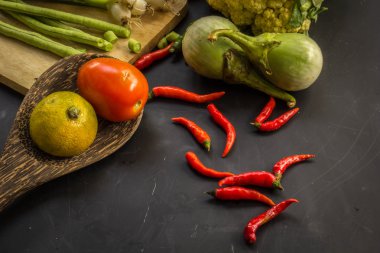 Young spring vegetables on black chalkboard from above. Backgrou