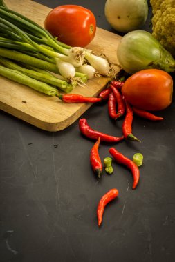 Young spring vegetables on black chalkboard from above. Backgrou
