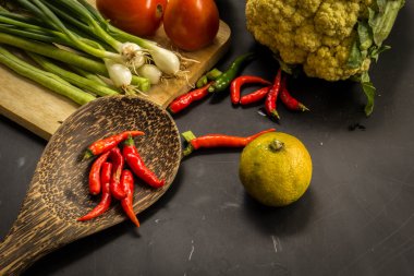 Young spring vegetables on black chalkboard from above. Backgrou