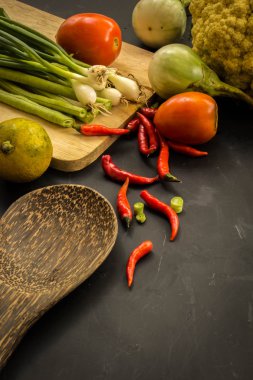 Young spring vegetables on black chalkboard from above. Backgrou