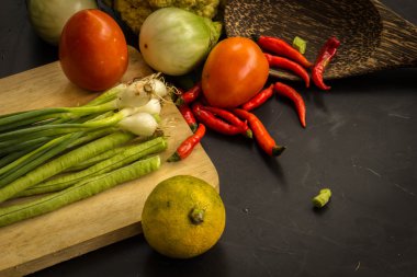 Young spring vegetables on black chalkboard from above. Backgrou