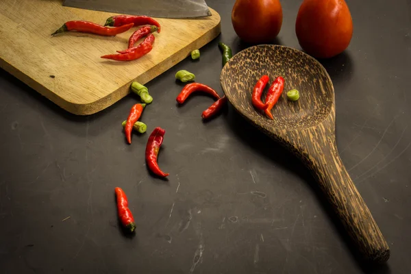 Young spring vegetables on black chalkboard from above. Backgrou