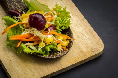 Mısır salata ve yerde siyah yemek kaşığı kırmızı şarap.