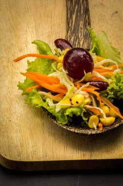 Mısır salata ve yerde siyah yemek kaşığı kırmızı şarap.