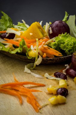 Mısır salata ve yerde siyah yemek kaşığı kırmızı şarap.