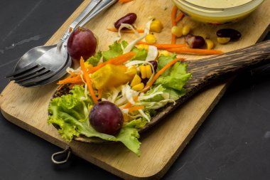 Mısır salata ve yerde siyah yemek kaşığı kırmızı şarap.