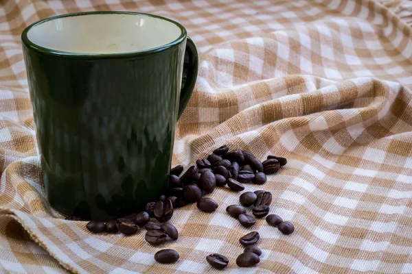 Cup full of coffee beans on cotton — Stock Photo, Image