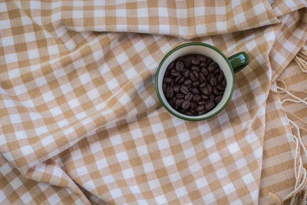 Cup full of coffee beans on cotton — Stock Photo, Image