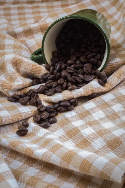 Cup full of coffee beans on cotton — Stock Photo, Image