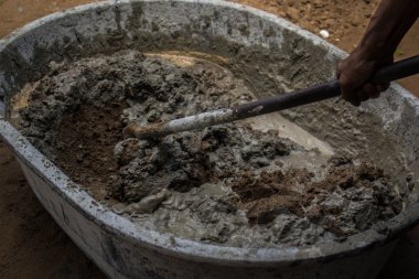 Kaldırımın yükseltilmesi sırasında çimento dökülüyor