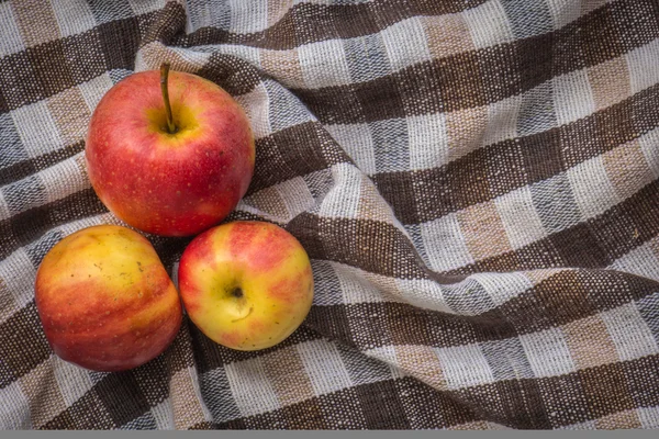 Imagem chave baixa de maçãs vermelhas sobre mesa texturizada de algodão wodden — Fotografia de Stock