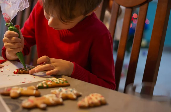 Das Kind Der Küche Hilft Mama Beim Dekorieren Der Weihnachtskuchen Stockbild