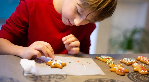 Das Kind Der Küche Hilft Mama Beim Dekorieren Der Weihnachtskuchen Stockfoto