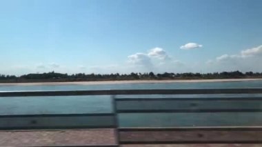 Kamera, bir aracın sürücü tarafındaki camından dışarı bakıyor.