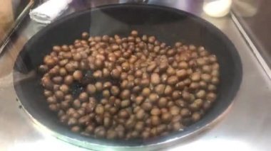 Chestnuts 'ı Çin mahallesinde kızartma makinesine kapatın. Tayland' da sokak yemekleri.