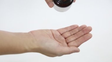 Pembe haplar beyaz arka planda kadınların ellerinden dökülüyor..