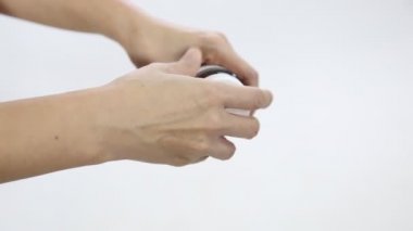 Pembe haplar beyaz arka planda kadınların ellerinden dökülüyor..