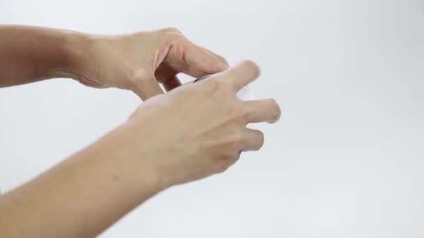 Рожеві таблетки, що виливаються з жіночої руки на білому матовому фоні . — стокове відео