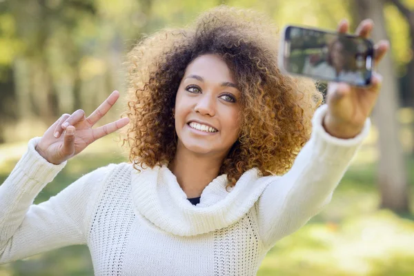 Bir akıllı telefon ile parkta genç Afro-Amerikan kız selfie — Stok fotoğraf