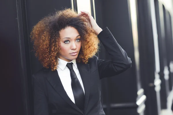 Mujer de negocios negro con traje y corbata en el fondo urbano — Foto de Stock
