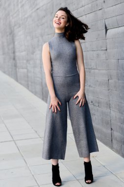 Kentsel arka planda rahat kıyafetler giyen genç kadın