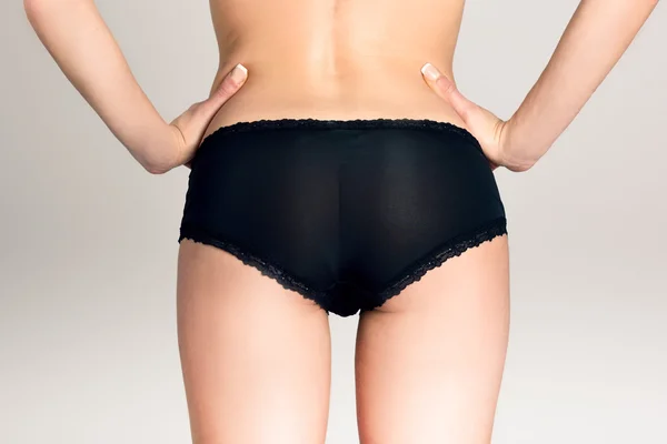 Female ass wearing black panties against white background — Stock Photo, Image