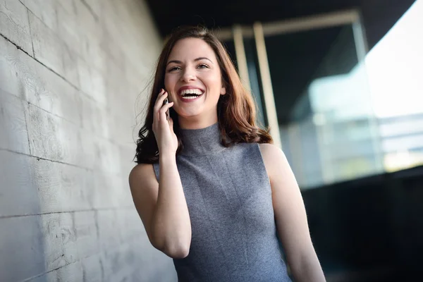 Businesswoman talking with a smartphone in an office building — Stock Photo, Image