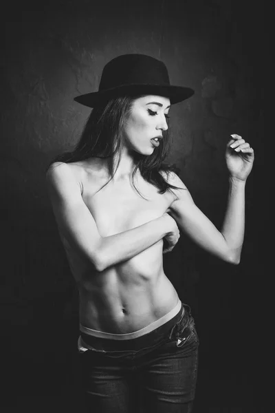 Topless woman wearing blue jeans, panties and hat — Stock Photo, Image