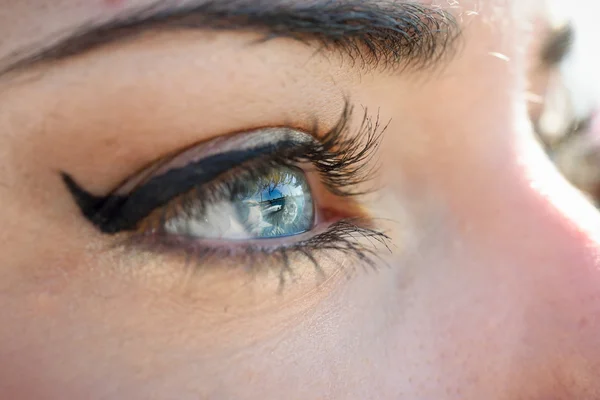 Primer plano de los ojos azules de la joven con pestañas largas — Foto de Stock