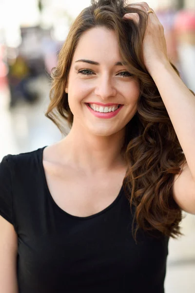 Mulher bonita com olhos azuis sorrindo em fundo urbano — Fotografia de Stock