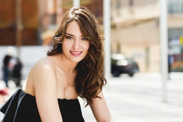 Hermosa joven con ojos azules sonriendo en el fondo urbano — Foto de Stock