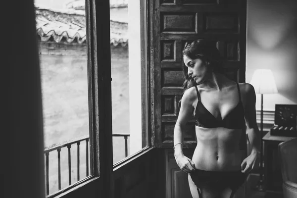 Σέξι νεαρή γυναίκα στο Lingerie Ποζάρει κοντά σε ένα παράθυρο — Φωτογραφία Αρχείου