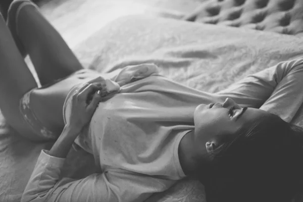 Сексуальна молода жінка в нижній білизні позує на ліжку — стокове фото