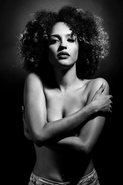 Junge schwarze Frau mit Afro-Frisur auf schwarzem Hintergrund — Stockfoto
