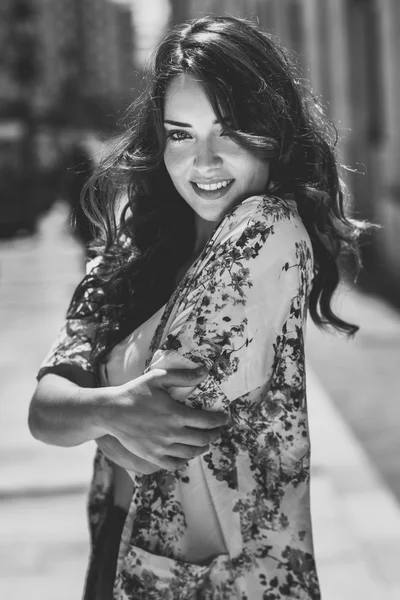 Beautiful young woman with blue eyes smiling in urban background — Stock Photo, Image