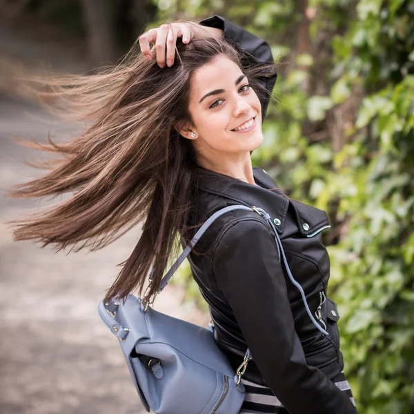 Mujer joven moviendo su cabello en el fondo urbano —  Fotos de Stock