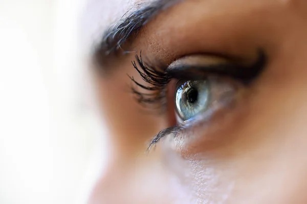 Primo piano degli occhi azzurri di giovane donna con ciglia lunghe — Foto Stock
