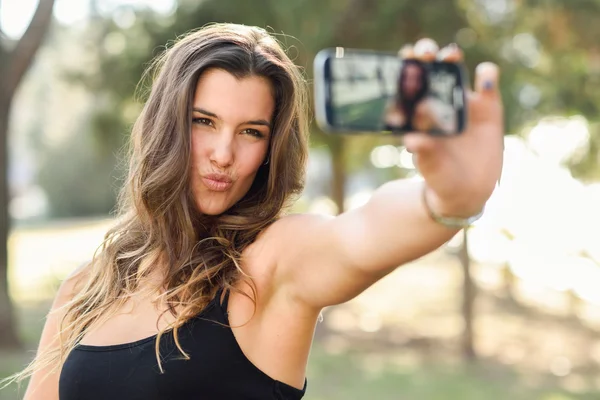 Krásná mladá žena selfie v parku — Stock fotografie