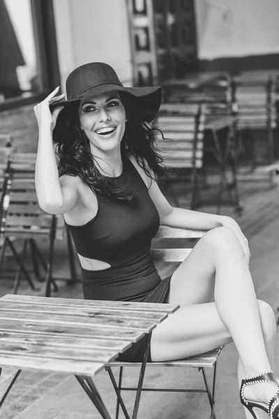 Açık havada barda oturmuş Siyah baştan çıkarıcı elbise giyen kadın — Stok fotoğraf