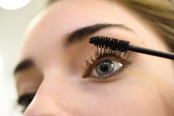 Maquillaje. Aplicando Mascara. Pestañas largas y ojos azules — Foto de Stock