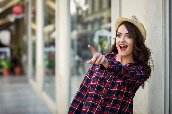 Young woman with beautiful blue eyes pointing with her finger — Stock Photo, Image