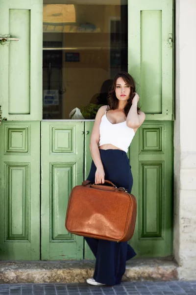 Yeşil kapı karşı vintage çanta ile güzel kız — Stok fotoğraf